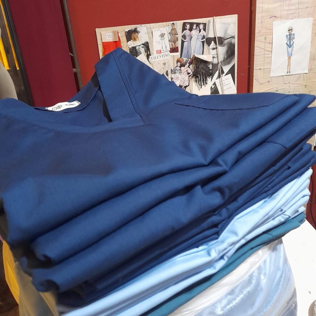 Pila de uniformes azules terminados, listos para entregar en Córdoba